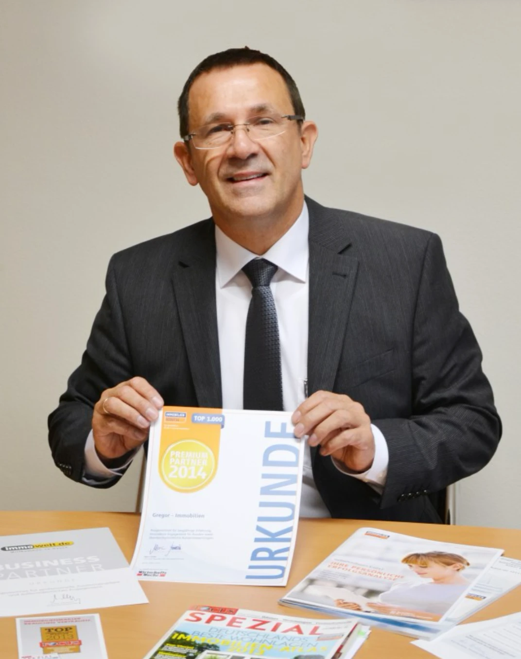Jürgen Gregor mit Auszeichnungen und Urkunde als ImmobilienScout24 Premium Partner